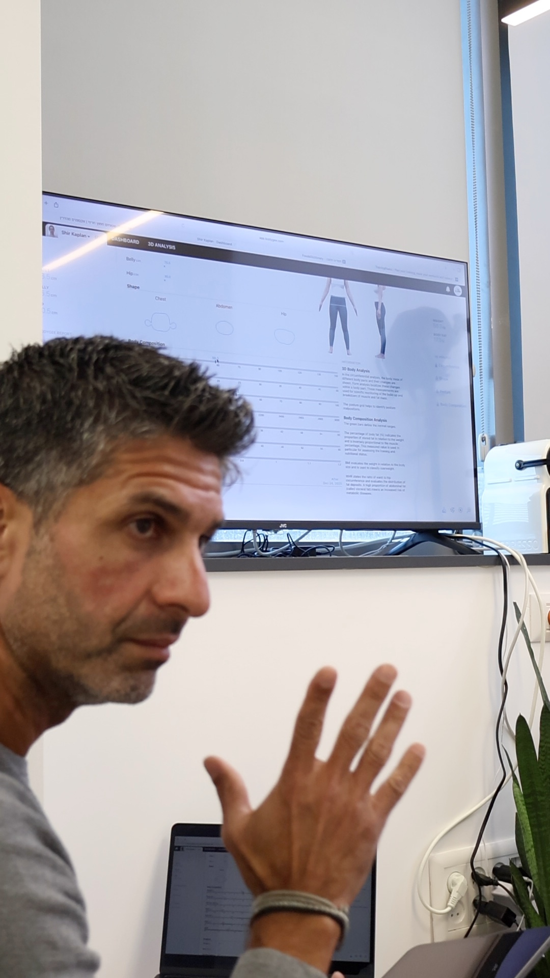 טל כרמל מסביר נתונים מקצועיים במהלך פגישה בקליניקה
